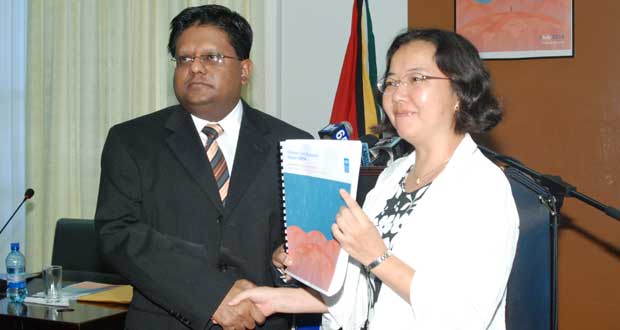 Minister of Finance, Dr. Ashni Singh, officially receives the 2014 Human Development report from Resident Representative, UNDP, Chisa Mikami (Photo Credit Guyana Chronicle)