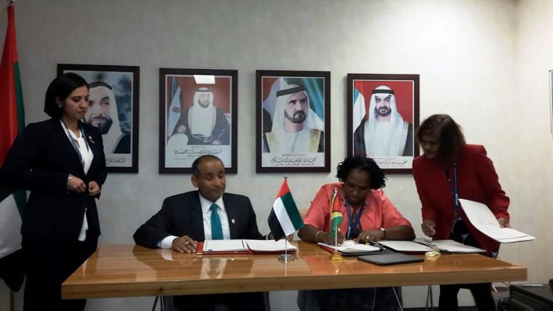 Minister Ferguson signing the agreement with an UAE official.