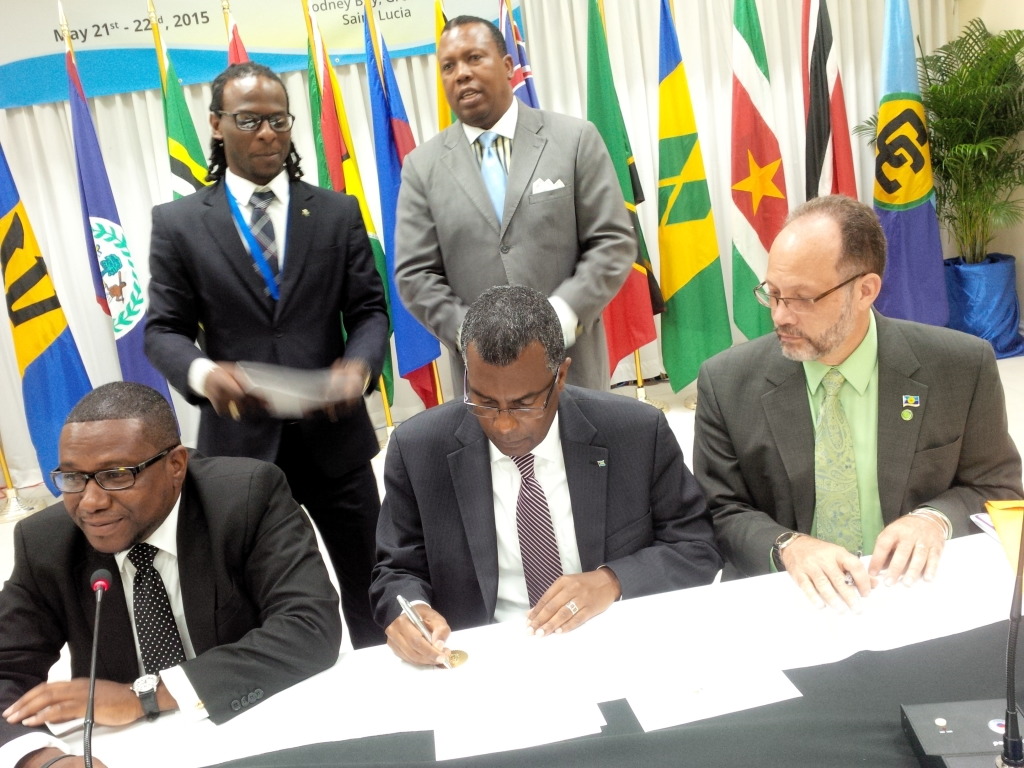 Hon. Fred Mitchell, Foreign Minister of The Bahamas (c) signs three agreements during the COFCOR Meeting in St. Lucia. COFCOR Chairman and Minister of Foreign Affairs of St. Lucia Hon. Alva Baptiste (l) and CARICOM Secretary-General Ambassador Irwin
