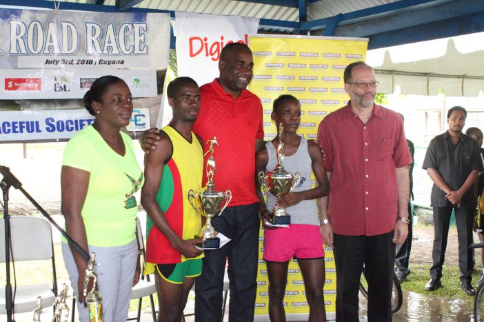 CARICOM 10k winners Cleveland Forde from Guyana and Linda McDonalnd from St. Vincent and the Grenadines pose for a photo with Minister in the Ministry of Sports, Guyana, Hon. Nicolette Henry. CARICOM Chairman and Prime Minister of Dominica Hon. Roose