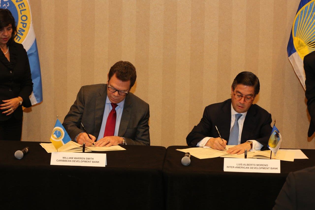 Dr. William Warren Smith, President of the Caribbean Development Bank (CDB) and Luis Alberto Moreno of the Inter-American Development Bank (IDB) sign the agreement (Photo via CDB)