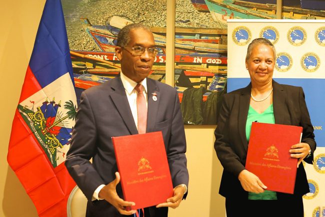 Haiti&rsquo;s Minister of Foreign Affairs, His Excellency Antonio Rodrigue (left) and Vice-President (Operations), Caribbean Development Bank (CDB), Monica La Bennett (right), hold the signed country agreements after signing them on February 27, 2018