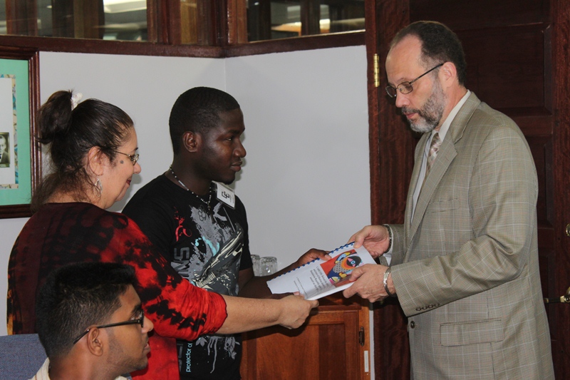 Mr. Marchenson Desrosier, a Haitian student at the University of Guyana, and Ms. Danuka Radzik, present the petition to Secretary-General Ambassador Irwin LaRocque.