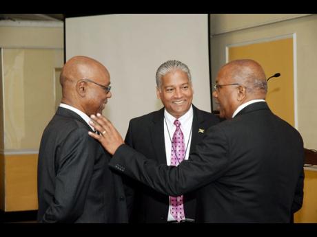Dr Morais Guy (right) in discussion with the chairman of the Jamaica Civil Aviation Authority (left), B. St Michael Hylton; and Director General of the Jamaica Civil Aviation Authority Nari Williams-Singh during the three-day meeting held at the Terr