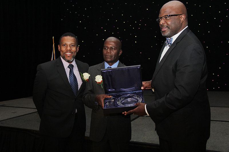 Mr. Ronald Jackson, Executive Director, CDEMA (left) joins the Hon. Adriel Brathwaite, Attorney General and Minister of Home Affairs, Barbados and Chairman of the CDEMA Council of Ministers (right) in presenting the award to Mr. Collymore (Bahamas In