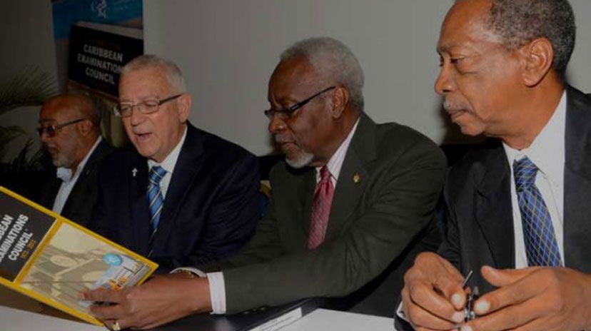 Former Prime Minister, the Most Hon. P.J. Patterson (2nd right), and Education Minister, Hon. Rev. Ronald Thwaites (2nd left), peruse a copy of the newly published book, &lsquo;A History of the Caribbean Examination Council, 1973-2013&rsquo;, written