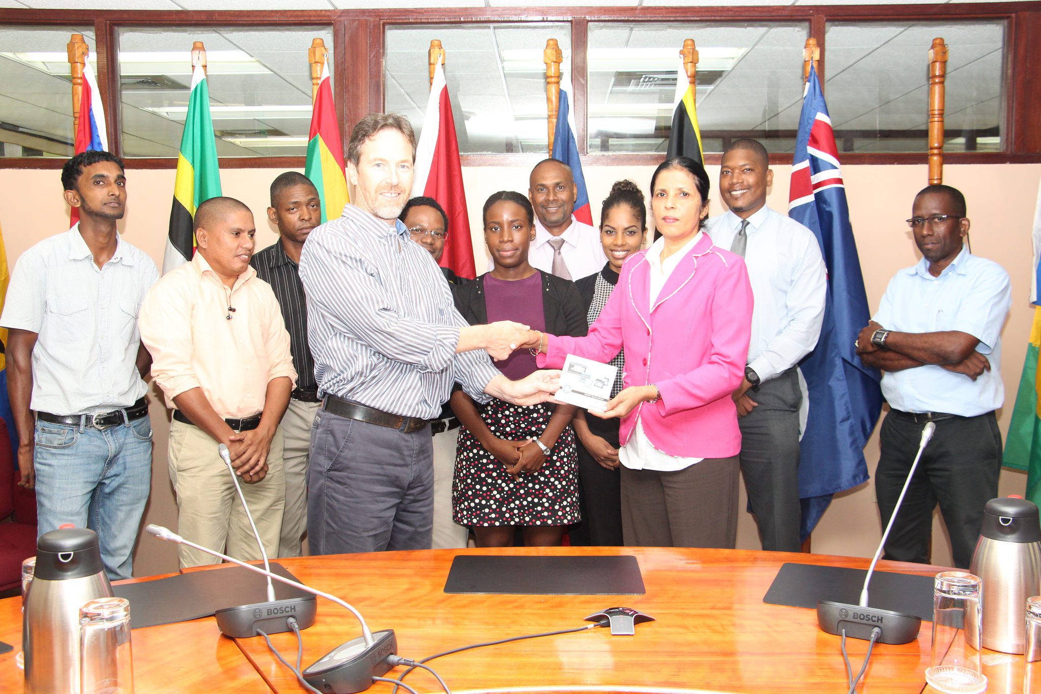 Mr. Glynn Morris of the GIZ/REETA Programme hands over the software to CARICOM DSG, Amb. Manorma Soeknandan PhD., in the presence of other CARICOM Secretariat staff members