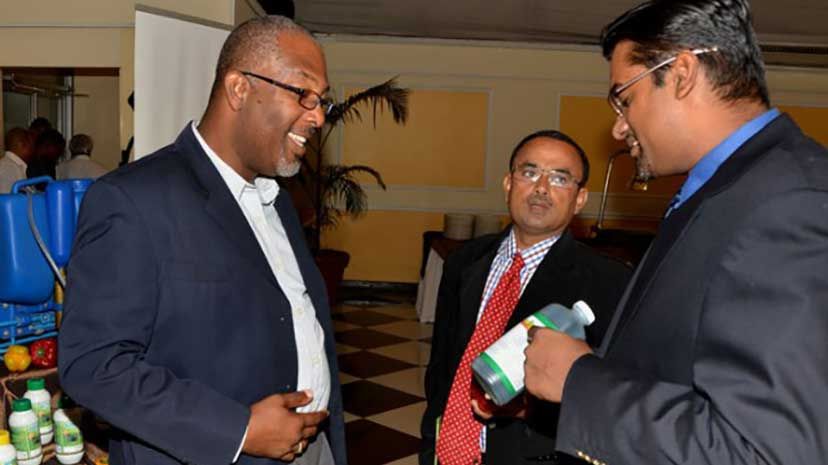 State Minister in the Ministry of Agriculture and Fisheries, Luther Buchanan (left), looks on as Christopher Persaud of Health 2000 (Guyana) Inc, points out features of a product in the Health 2000 (H2K) AGRO line. Occasion was the recent launch of H