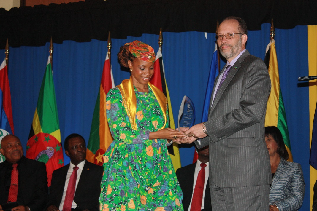Winner of the CARICOM Song Competition Michele Henderson accepts her award from Secretary General of the Caribbean Community Ambassador Irwin LaRocque