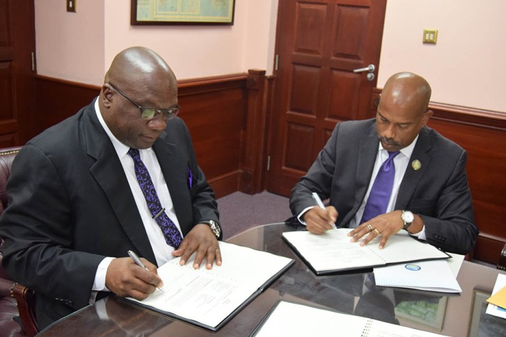 Prime Minister Dr. the Hon. Timothy Harris and CDF CEO Mr. Rodinald Soomer sign CDF agreement (Photo via SKNIS)