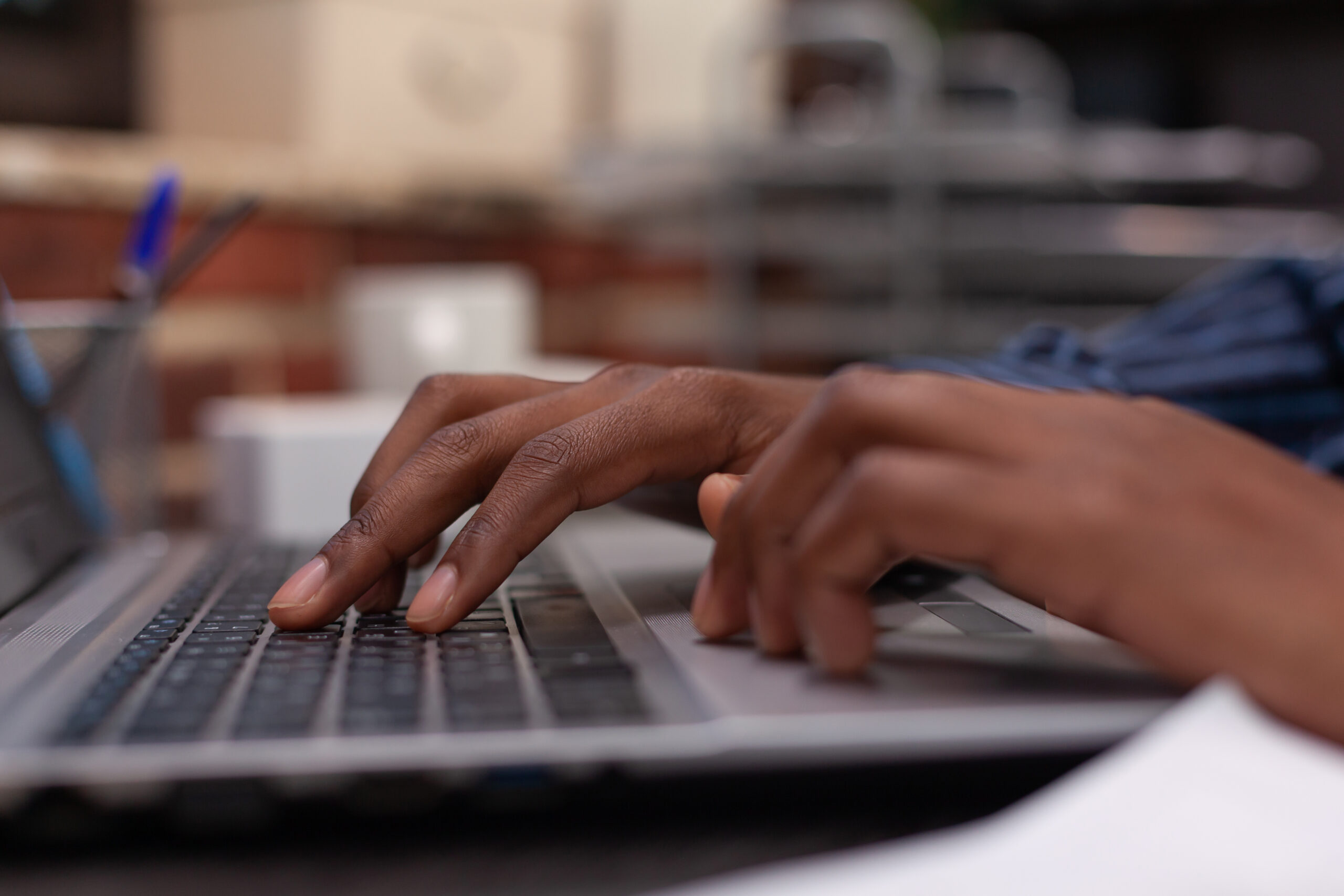 Closeup of african american hands typing business data on portable computer keyboard