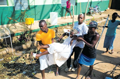 A woman with cholera is carried by residents to a cholera centre in Anse D&rsquo;Hainault, Haiti on October 11.