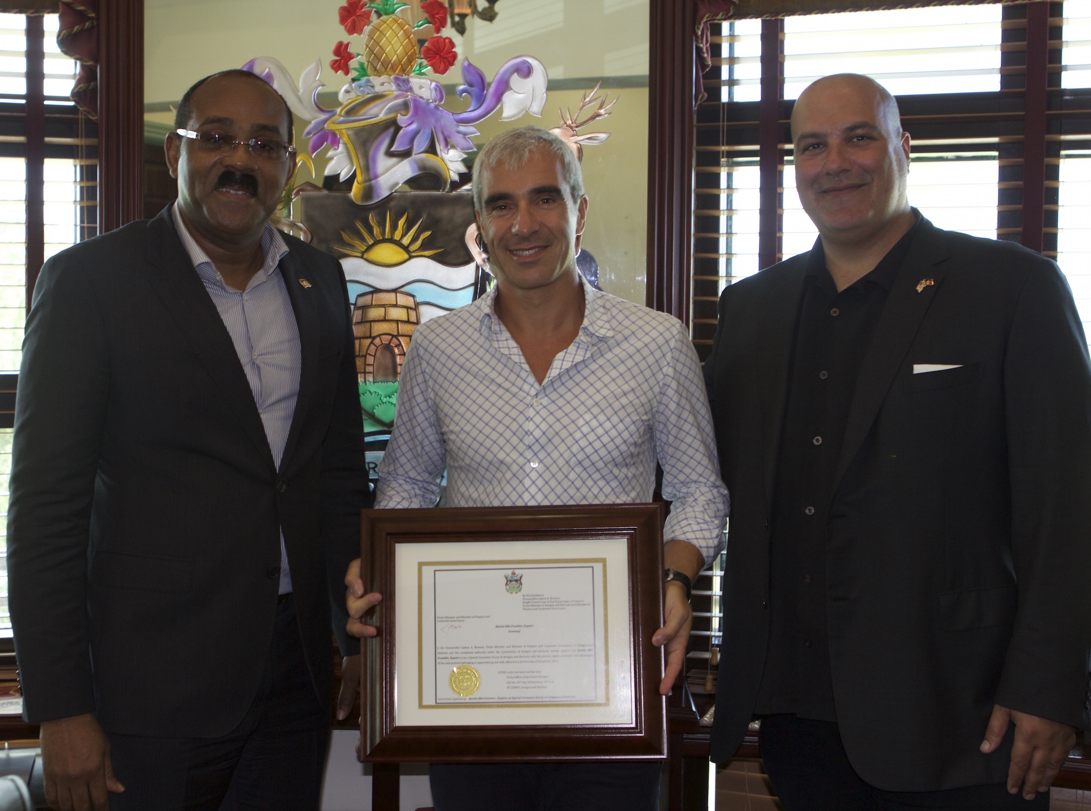PM Browne presenting the Instrument of Appointment to Mr. Martin Franklin.  Ambassador Boustany was on hand for the presentation.