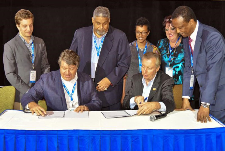 Director General and CEO of CHTA Frank Comito (seated at right) and USAID CARCEP&rsquo;s Energy Efficiency Promotion Specialist John Marcocchio at yesterday&rsquo;s signing in Puerto Rico. Standing from left is Jonathan Schwartz of Deloitte Consultin