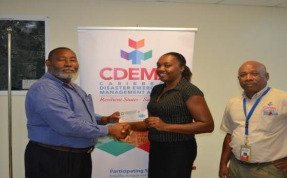 Philmore Mullin, Director of NODS, Antigua &amp;amp; Barbuda and Brigadier General (Rtd) Earl Arthurs, Consultant with the CDEMA CU captured above presenting a Grocery Voucher to Salome Deazle.