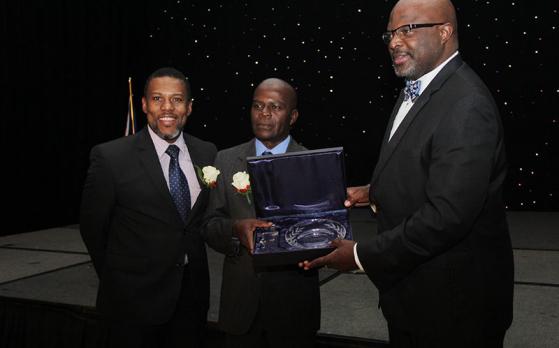 Mr. Ronald Jackson, Executive Director, CDEMA (left) joins the Hon. Adriel Brathwaite, Attorney General and Minister of Home Affairs, Barbados and Chairman of the CDEMA Council of Ministers (right) in presenting the award to Mr. Collymore (Bahamas In