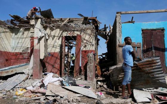 Men salvage metal sheets from a destroyed house after Hurricane Matthew passes in Jeremie, Haiti (CARLOS GARCIA RAWLINS/REUTERS)