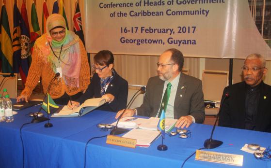 Senator The Hon. Kamina Johnson-Smith, Minister of Foreign Affairs and Foreign Trade of Jamaica, signing the Amendment to the CDF Agreement, while CARICOM Secretary-General Ambassador Irwin LaRocque looks on
